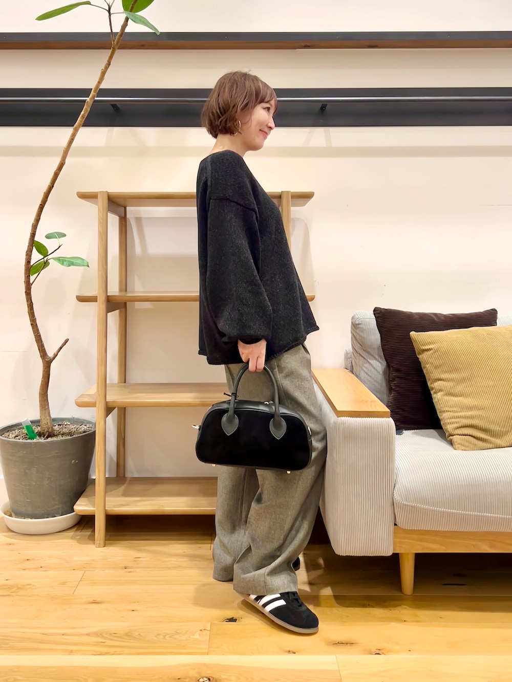 ブラック系のニット/セーター、ブラック系のショルダーバッグ、グレー系のその他パンツを着用したレディースの秋コーディネートの2枚目の写真