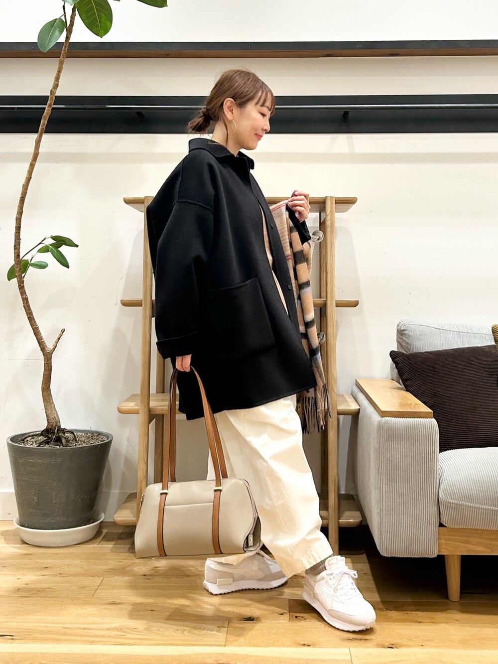ベージュ系のニット/セーター、ホワイト系のその他パンツ、ブラック系のボストンバッグを着用したレディースの冬コーディネートの8枚目の写真