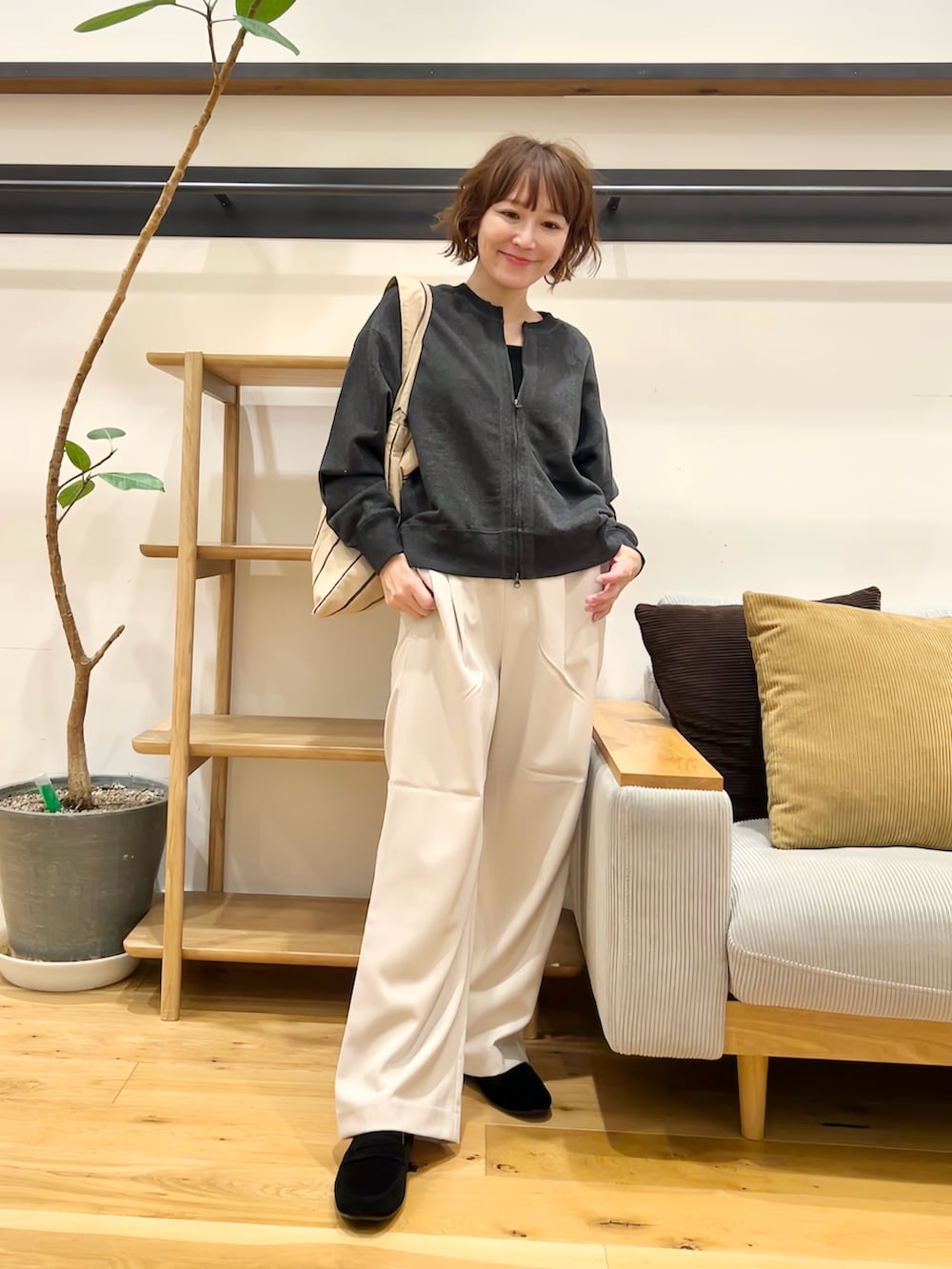 グレー系のカーディガン/ボレロ、グレー系のその他パンツ、ベージュ系のトートバッグを着用したレディースの秋コーディネートの3枚目の写真