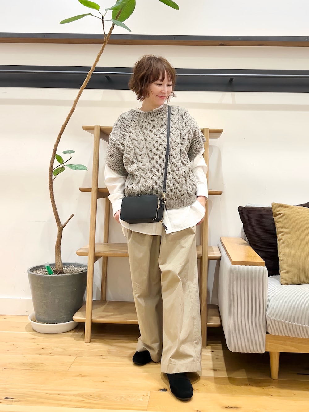 グレー系のニット/セーター、ホワイト系のシャツ/ブラウス、ブラック系のショルダーバッグを着用したレディースの秋コーディネートの5枚目の写真