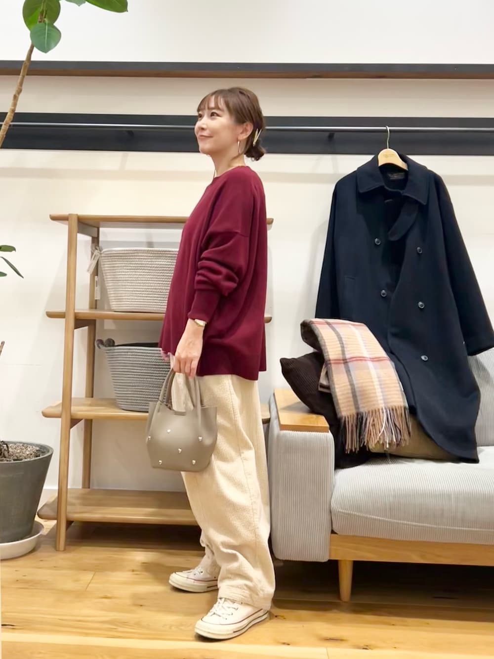 レッド系のニット/セーター、ブラック系のショルダーバッグ、ホワイト系のその他パンツを着用したレディースの冬コーディネートの2枚目の写真