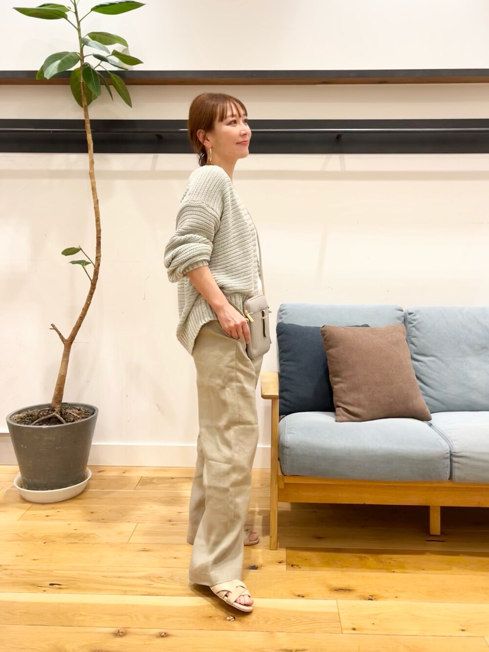 グリーン系のカーディガン/ボレロ、グレー系のショルダーバッグ、ベージュ系のパンツを着用したレディースの春コーディネートの2枚目の写真