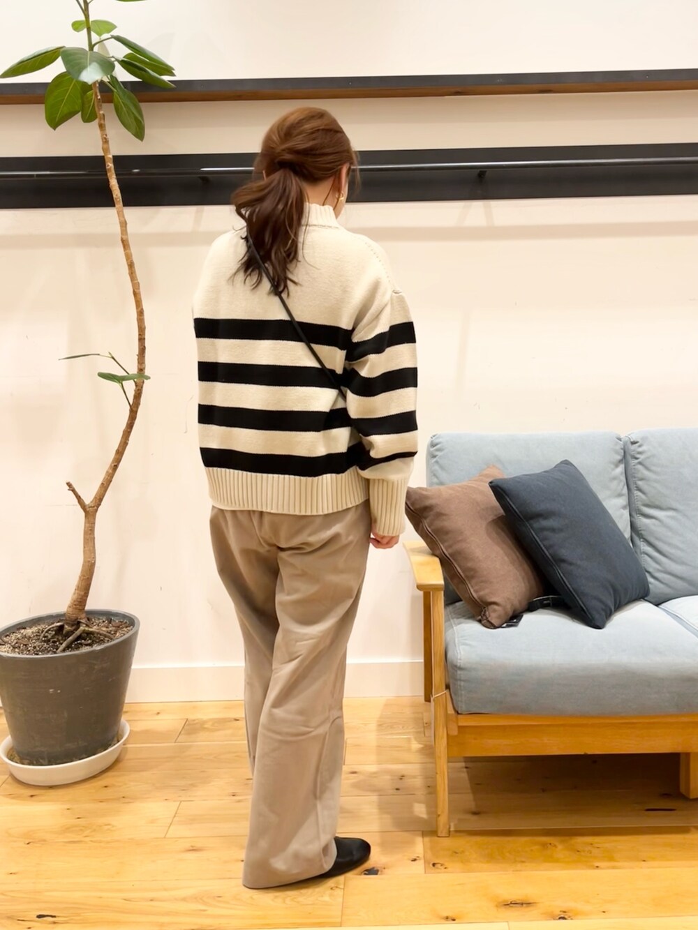 ホワイト系のニット/セーター、ブラック系のショルダーバッグ、ベージュ系のその他パンツを着用したレディースの冬コーディネートの3枚目の写真