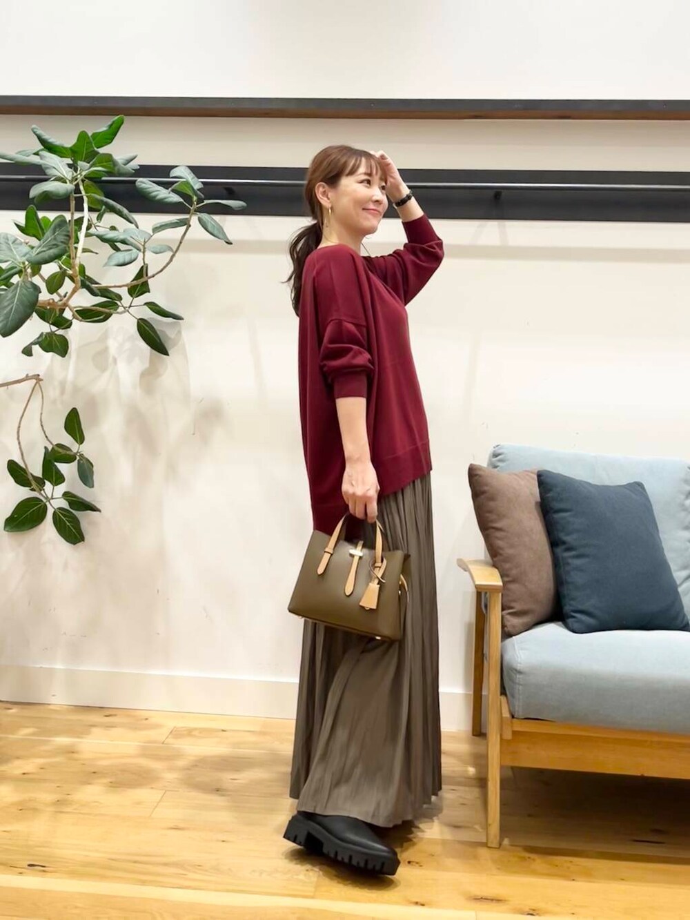 ブラック系のブーツ、レッド系のニット/セーター、ブラウン系のハンドバッグを着用したレディースの秋コーディネートの4枚目の写真