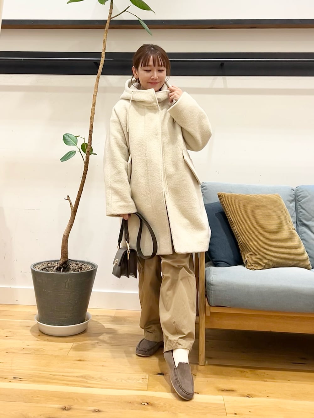 グリーン系のニット/セーター、ベージュ系のその他パンツ、ホワイト系のシャツ/ブラウスを着用したレディースの冬コーディネートの6枚目の写真