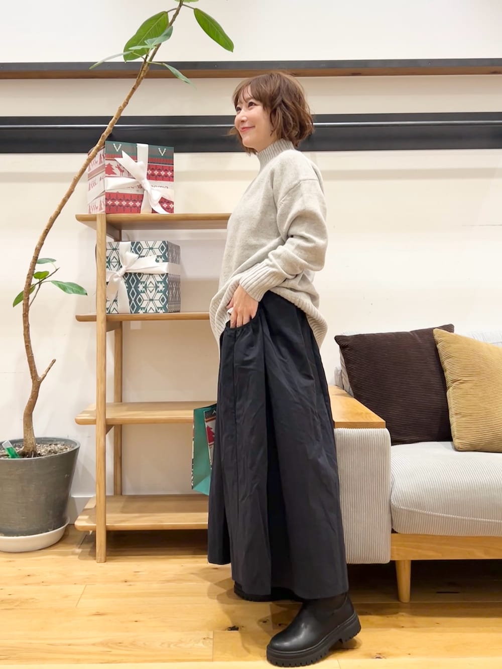 グレー系のニット/セーター、ブルー系のスカート、ブラック系のブーツを着用したレディースの冬コーディネートの5枚目の写真