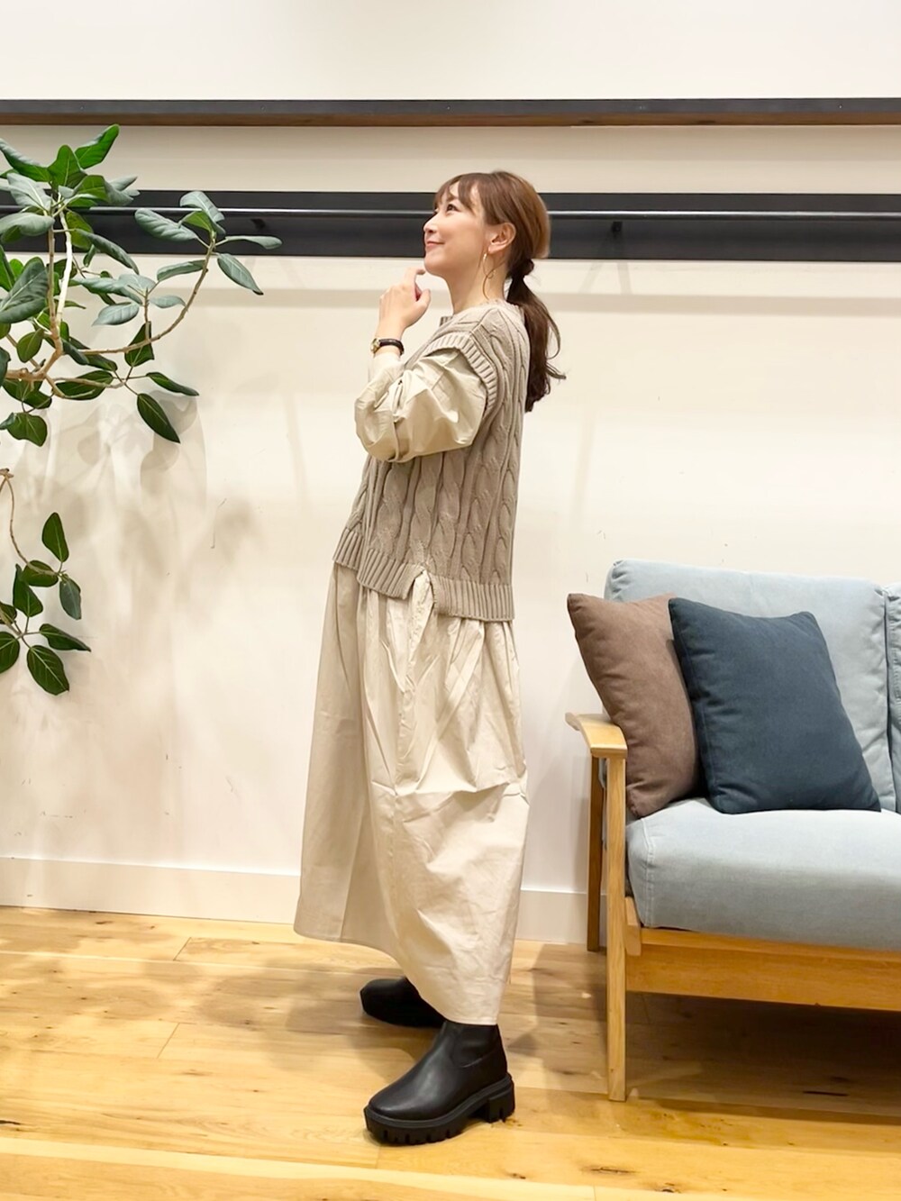 ベージュ系のワンピース、ブラック系のショルダーバッグ、ブラック系のブーツを着用したレディースの秋コーディネートの3枚目の写真
