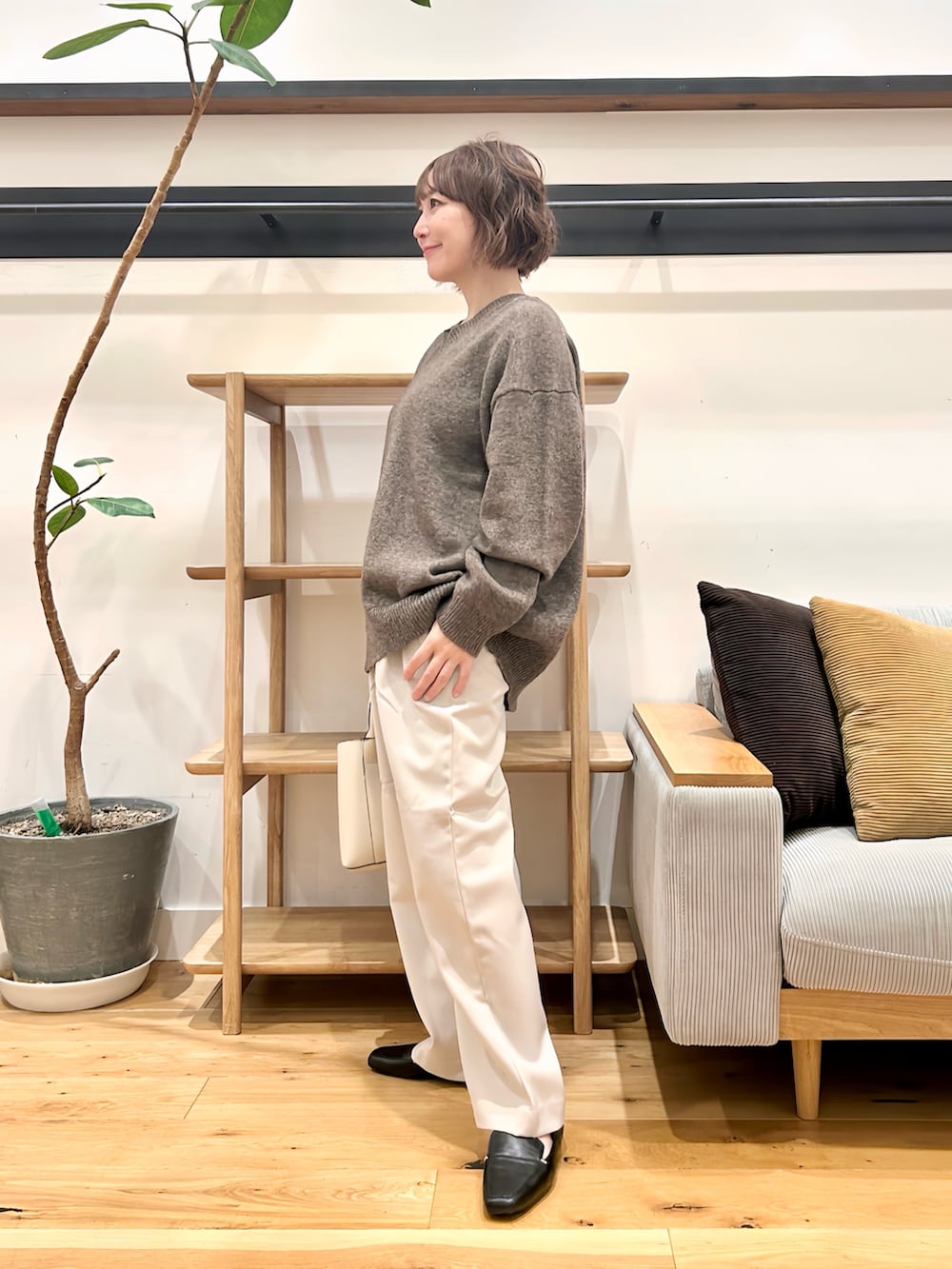 ブラウン系のニット/セーター、グレー系のその他パンツ、オレンジ系のトートバッグを着用したレディースの秋コーディネートの2枚目の写真