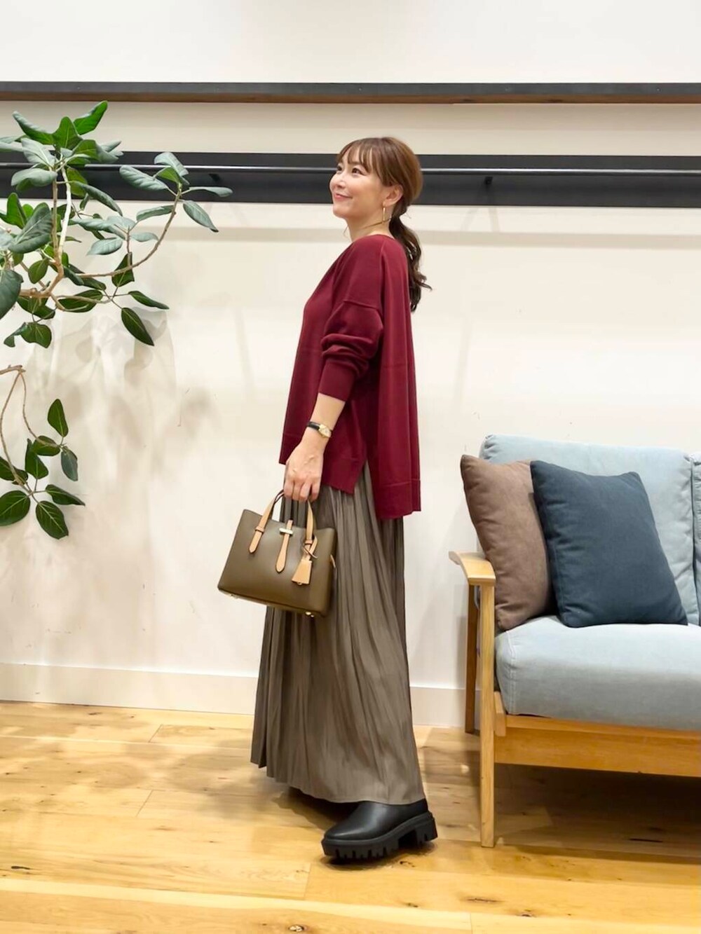 ブラック系のブーツ、レッド系のニット/セーター、ブラウン系のハンドバッグを着用したレディースの秋コーディネートの3枚目の写真