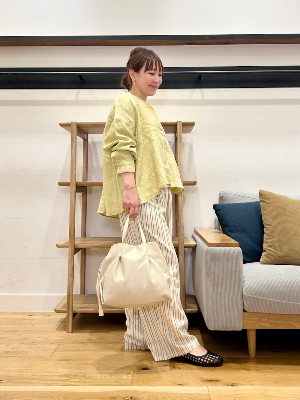 イエロー系のシャツ/ブラウス、ベージュ系のその他パンツ、ホワイト系のショルダーバッグを着用したレディースの春コーディネートの4枚目の写真