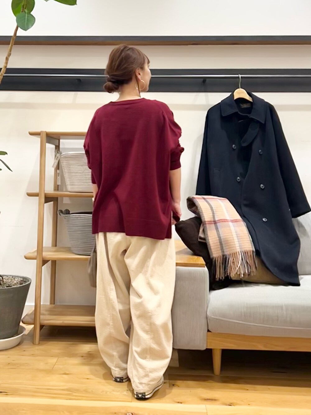 レッド系のニット/セーター、ブラック系のショルダーバッグ、ホワイト系のその他パンツを着用したレディースの冬コーディネートの3枚目の写真