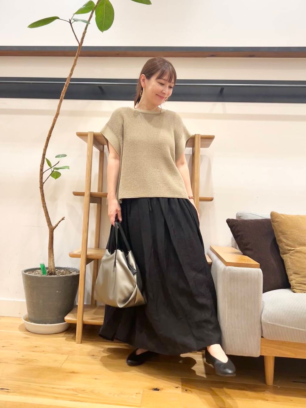 シルバー系のショルダーバッグ、ブラック系のパンプス、ベージュ系のニット/セーターを着用したレディースの夏コーディネートの4枚目の写真