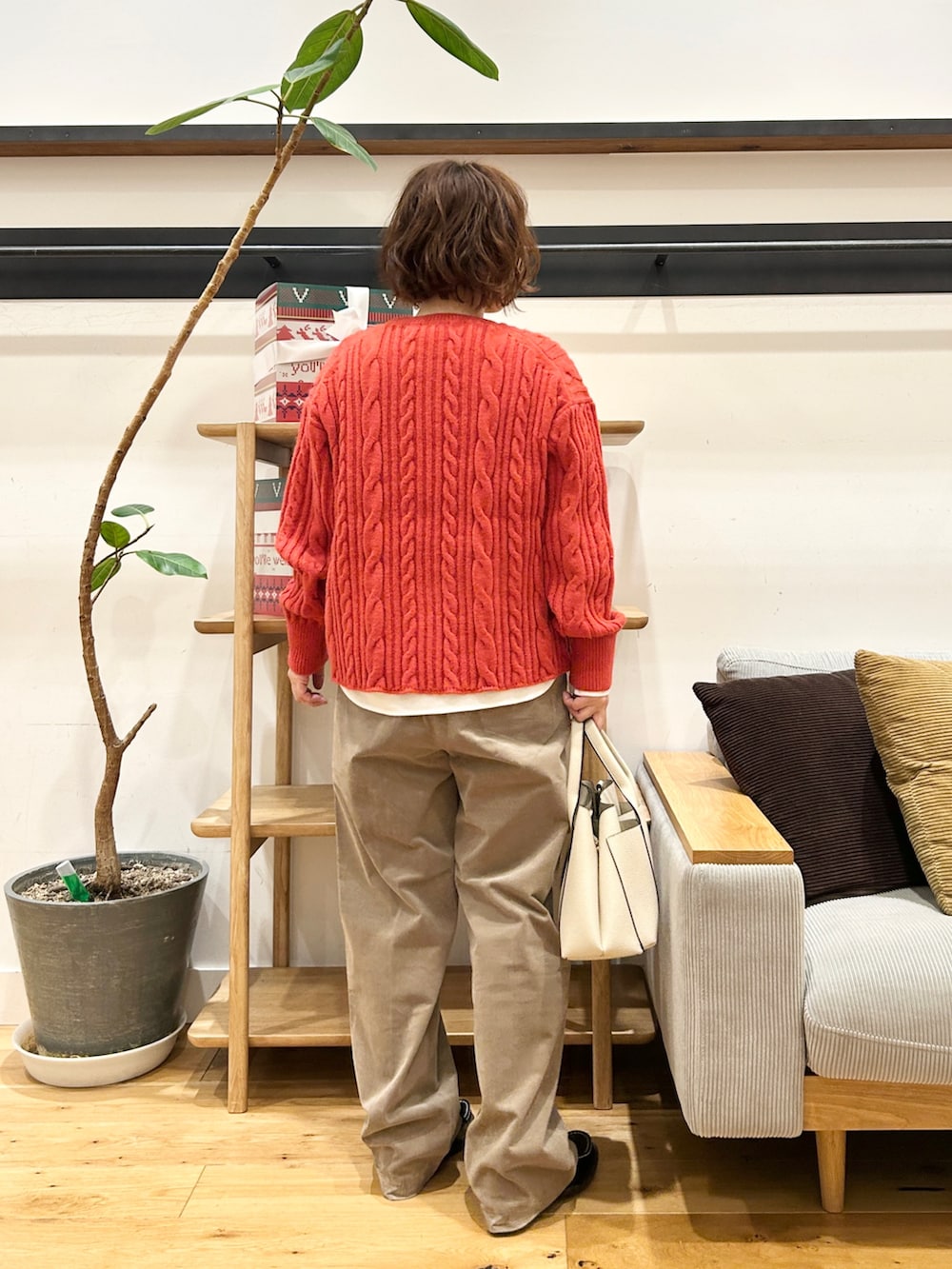 オレンジ系のニット/セーター、ホワイト系のTシャツ/カットソー、ベージュ系のその他パンツを着用したレディースの冬コーディネートの3枚目の写真