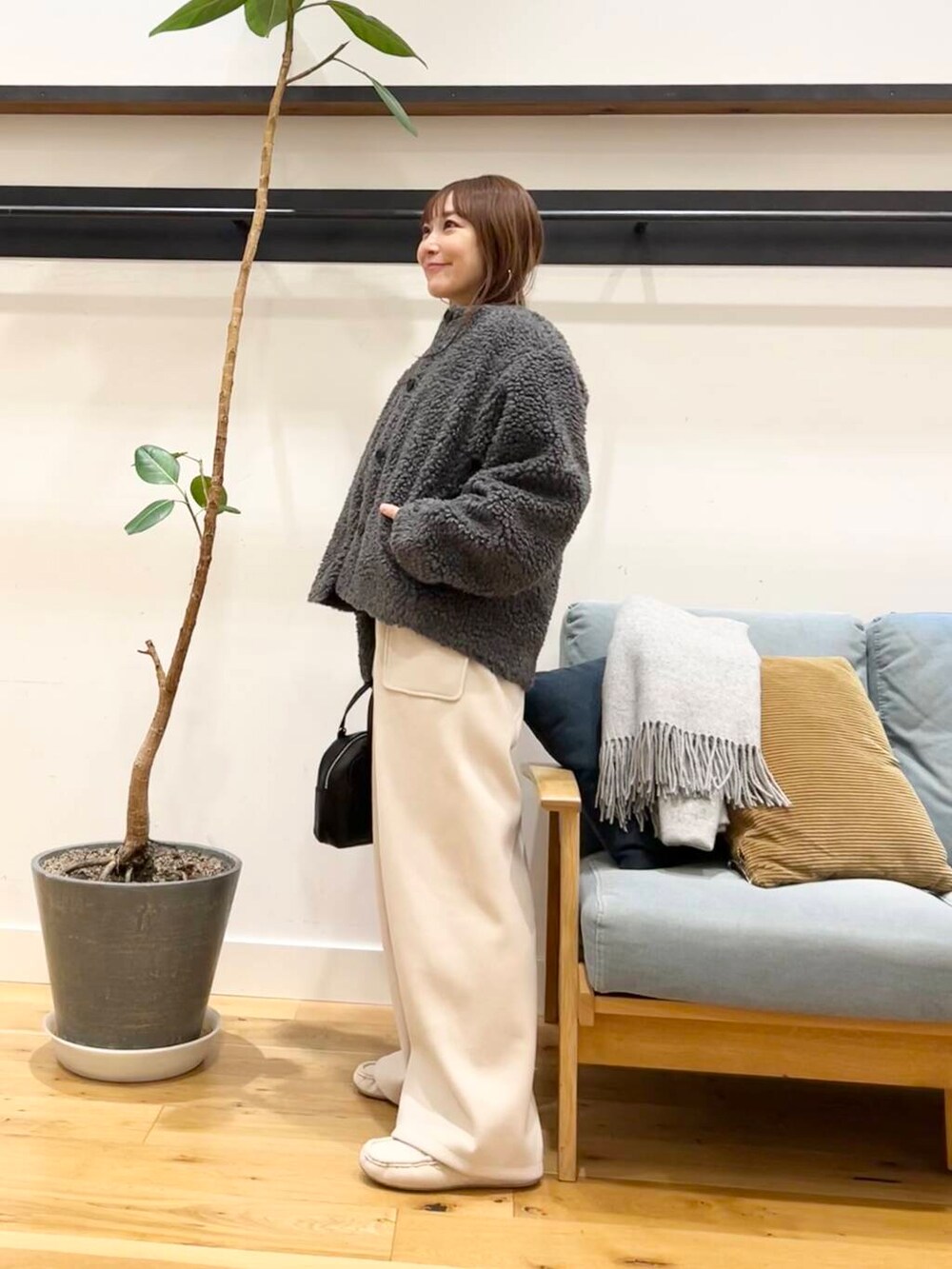 ブラック系のショルダーバッグ、グレー系のその他アウター、ホワイト系のその他パンツを着用したレディースの冬コーディネートの6枚目の写真