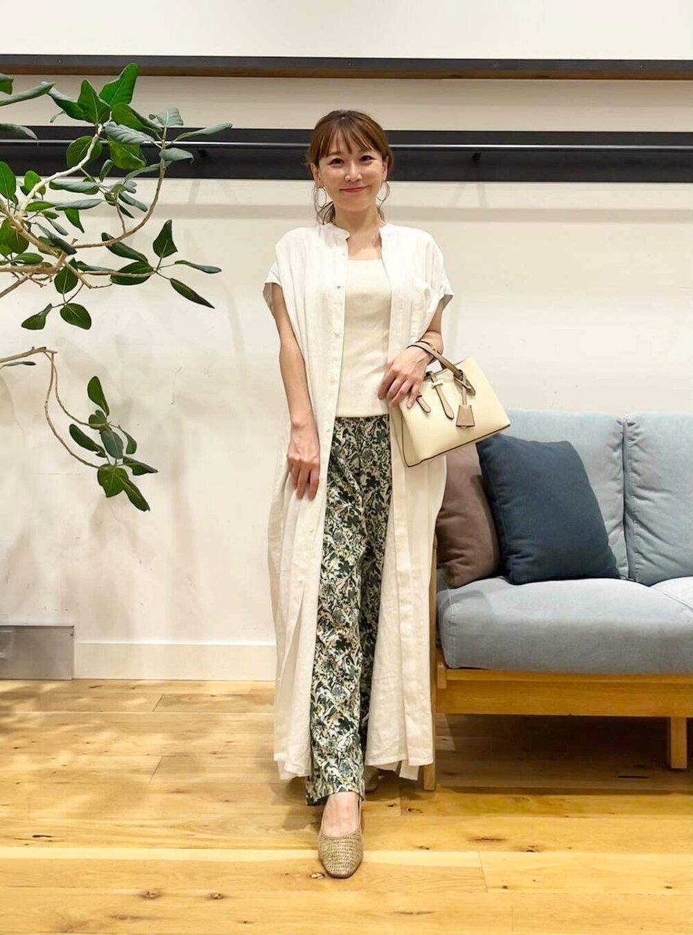 ホワイト系のハンドバッグ、ベージュ系のパンプス、ホワイト系のワンピースを着用したレディースの夏コーディネートの3枚目の写真