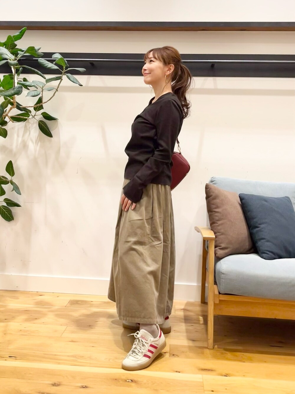 ブラウン系のTシャツ/カットソー、ベージュ系のスカート、グリーン系のショルダーバッグを着用したレディースの秋コーディネートの2枚目の写真