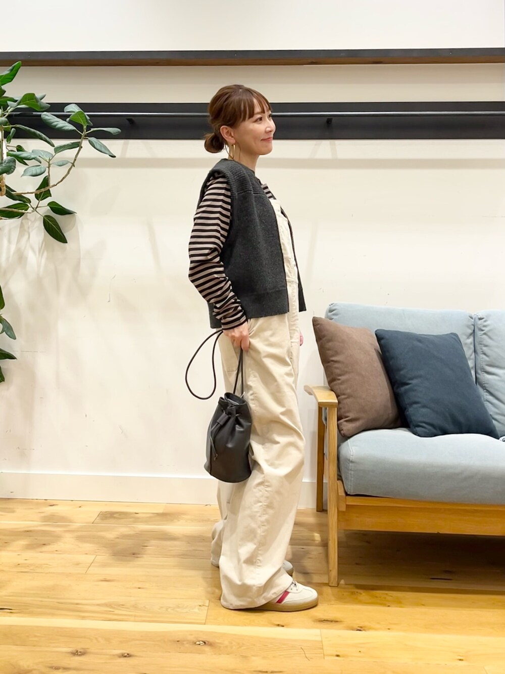 ホワイト系のサロペット/オーバーオール、グレー系のベスト、ベージュ系のTシャツ/カットソーを着用したレディースの秋コーディネートの4枚目の写真