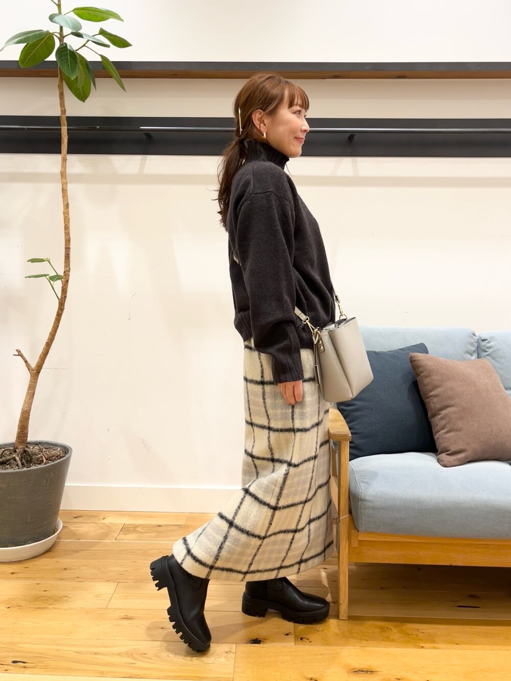 ブルー系のニット/セーター、ベージュ系のスカート、グレー系のショルダーバッグを着用したレディースの冬コーディネートの4枚目の写真