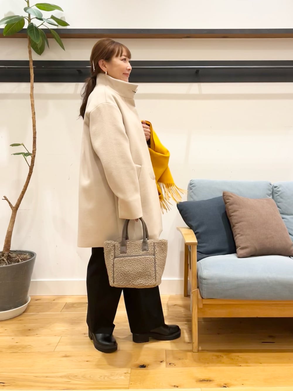 ホワイト系のその他アウター、ブラック系のその他パンツ、ベージュ系のショルダーバッグを着用したレディースの冬コーディネートの2枚目の写真