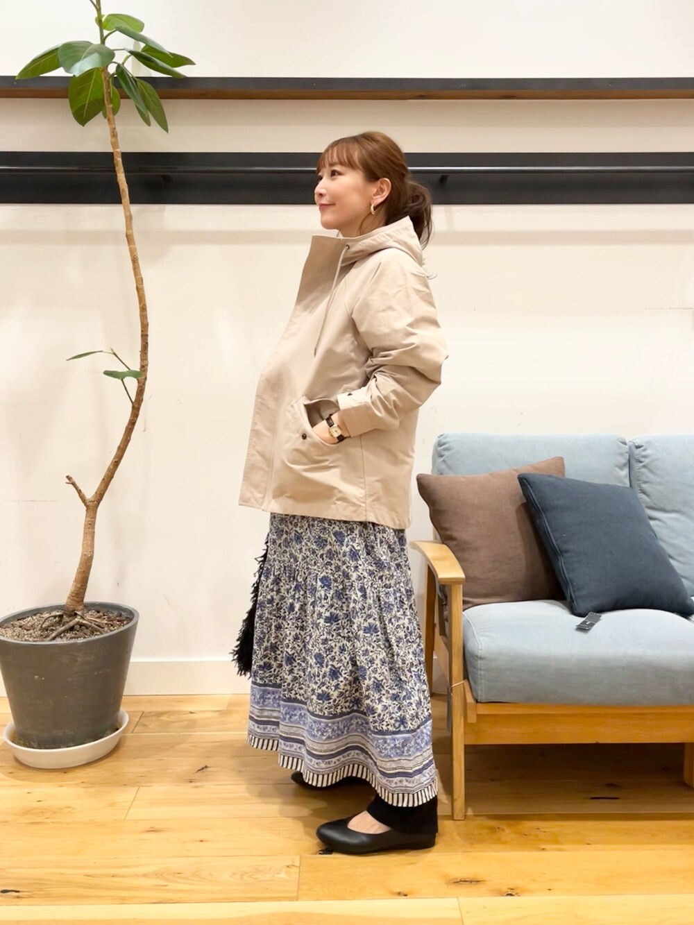 ベージュ系のマウンテンパーカー、ブルー系のワンピース、ブラック系のショルダーバッグを着用したレディースの冬コーディネートの2枚目の写真