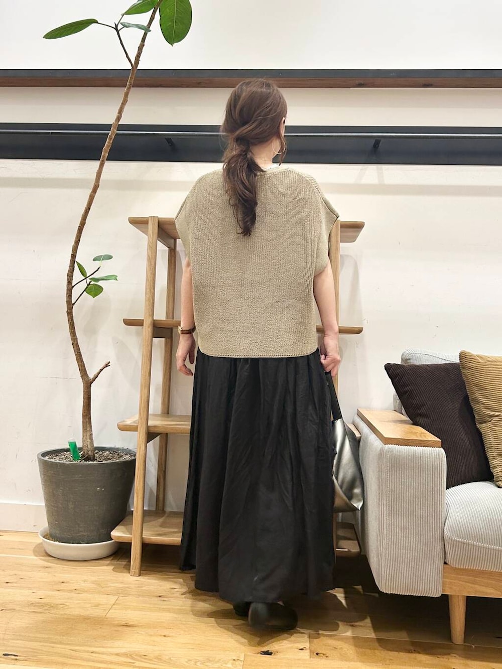 シルバー系のショルダーバッグ、ブラック系のパンプス、ベージュ系のニット/セーターを着用したレディースの夏コーディネートの5枚目の写真