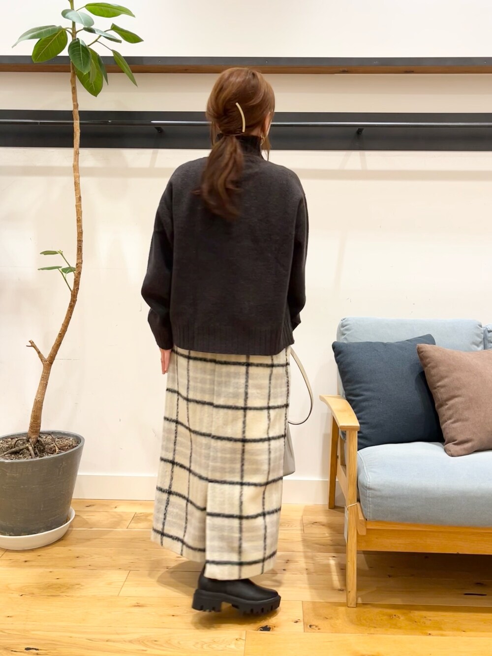 ブルー系のニット/セーター、ベージュ系のスカート、グレー系のショルダーバッグを着用したレディースの冬コーディネートの3枚目の写真