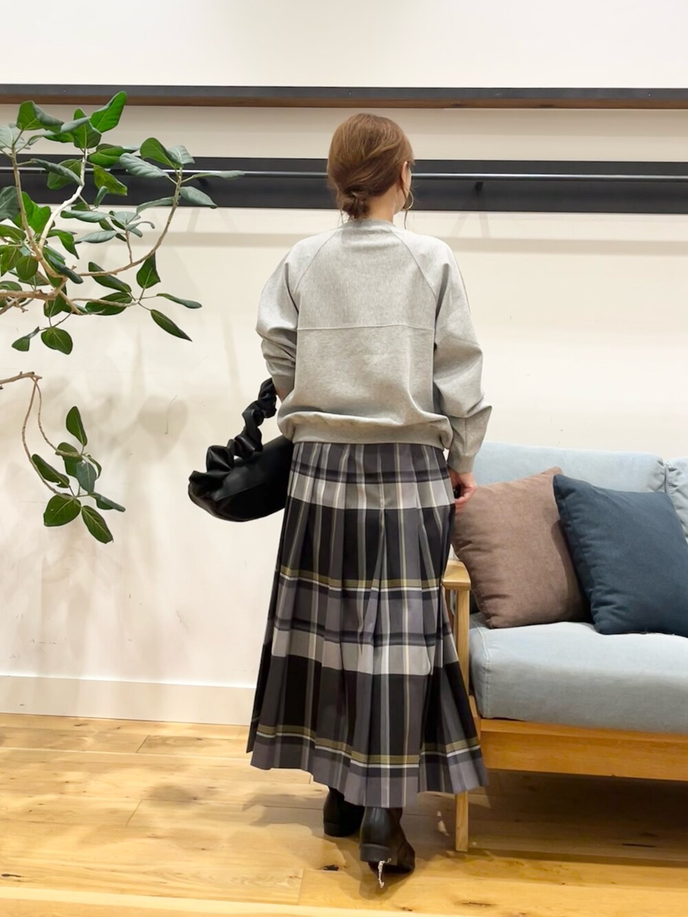 ブルー系のスカート、グレー系のカーディガン/ボレロ、ブラック系のブーツを着用したレディースの秋コーディネートの3枚目の写真