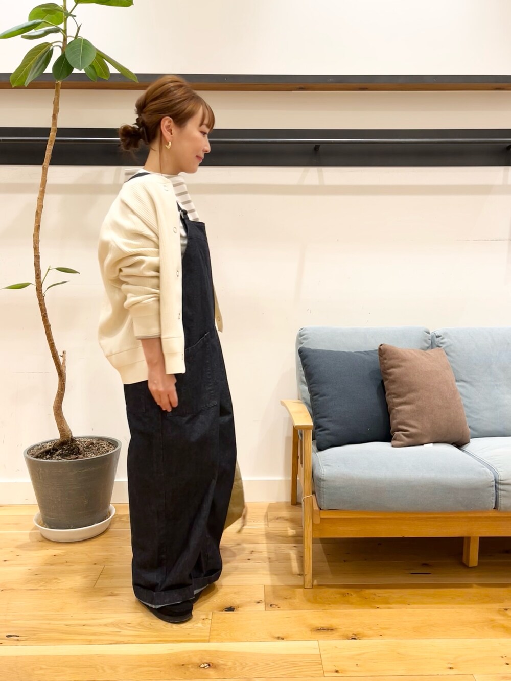 ホワイト系のカーディガン/ボレロ、ベージュ系のTシャツ/カットソー、ブルー系のオールインワン・サロペットを着用したレディースの冬コーディネートの2枚目の写真