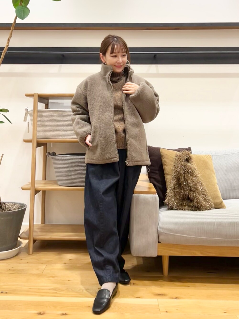 ブラウン系のニット/セーター、ブラウン系のトートバッグ、ブルー系のデニムパンツを着用したレディースの冬コーディネートの5枚目の写真