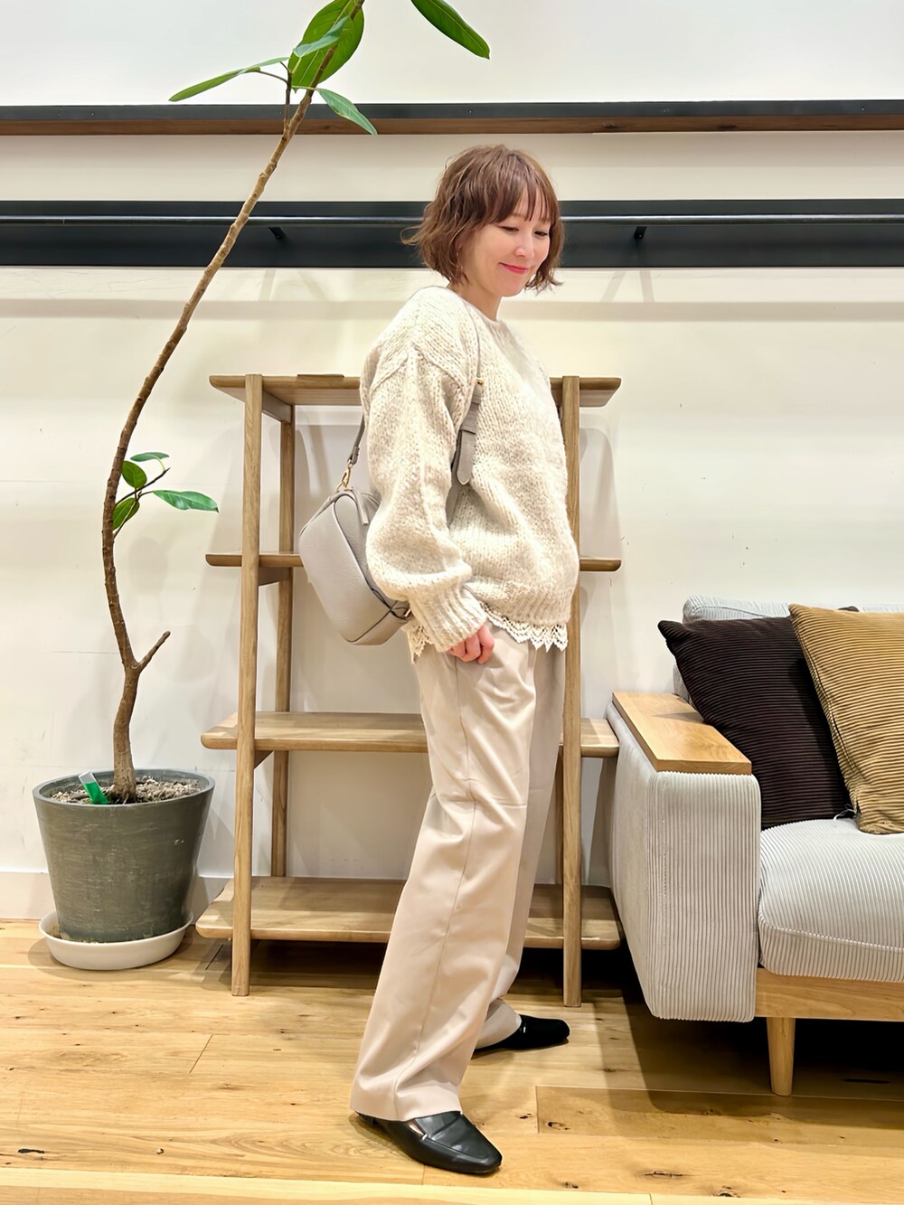 グレー系のニット/セーター、ホワイト系のTシャツ/カットソー、ベージュ系のその他パンツを着用したレディースの秋コーディネートの2枚目の写真