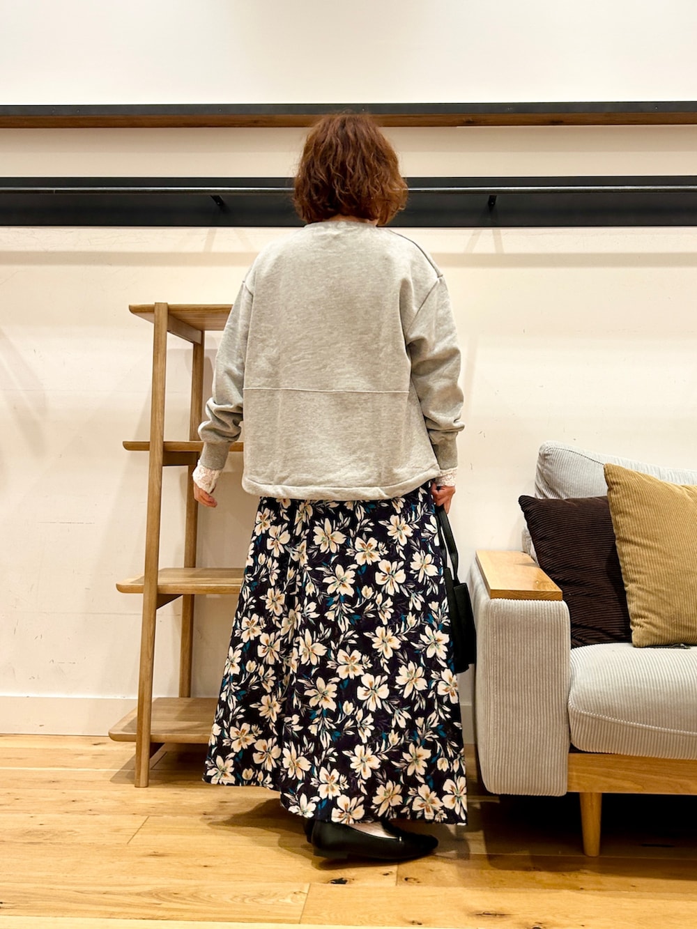 グレー系のスウェット、ブルー系のスカート、オレンジ系のトートバッグを着用したレディースの冬コーディネートの3枚目の写真