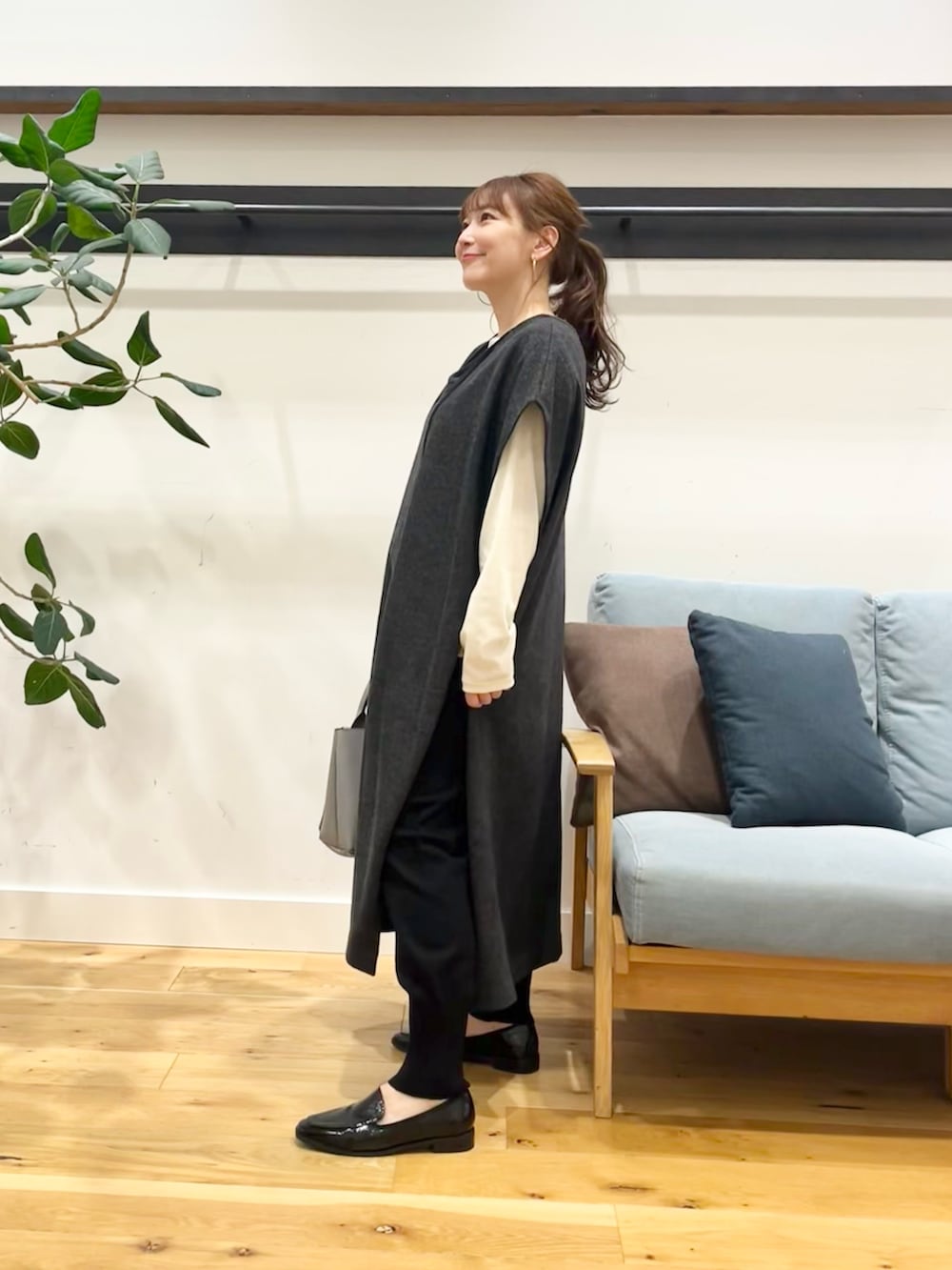 グレー系のワンピース、ホワイト系のTシャツ/カットソー、レッド系のトートバッグを着用したレディースの秋コーディネートの3枚目の写真
