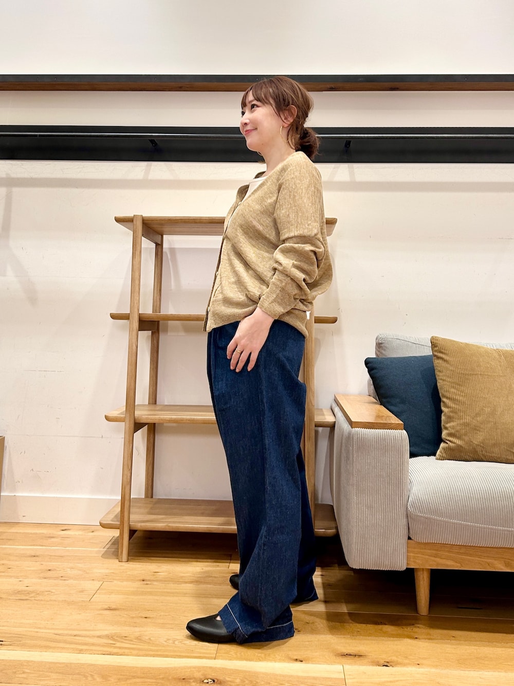 ベージュ系のカーディガン/ボレロ、ホワイト系のタンクトップ、ブルー系のデニムパンツを着用したレディースの春コーディネートの4枚目の写真