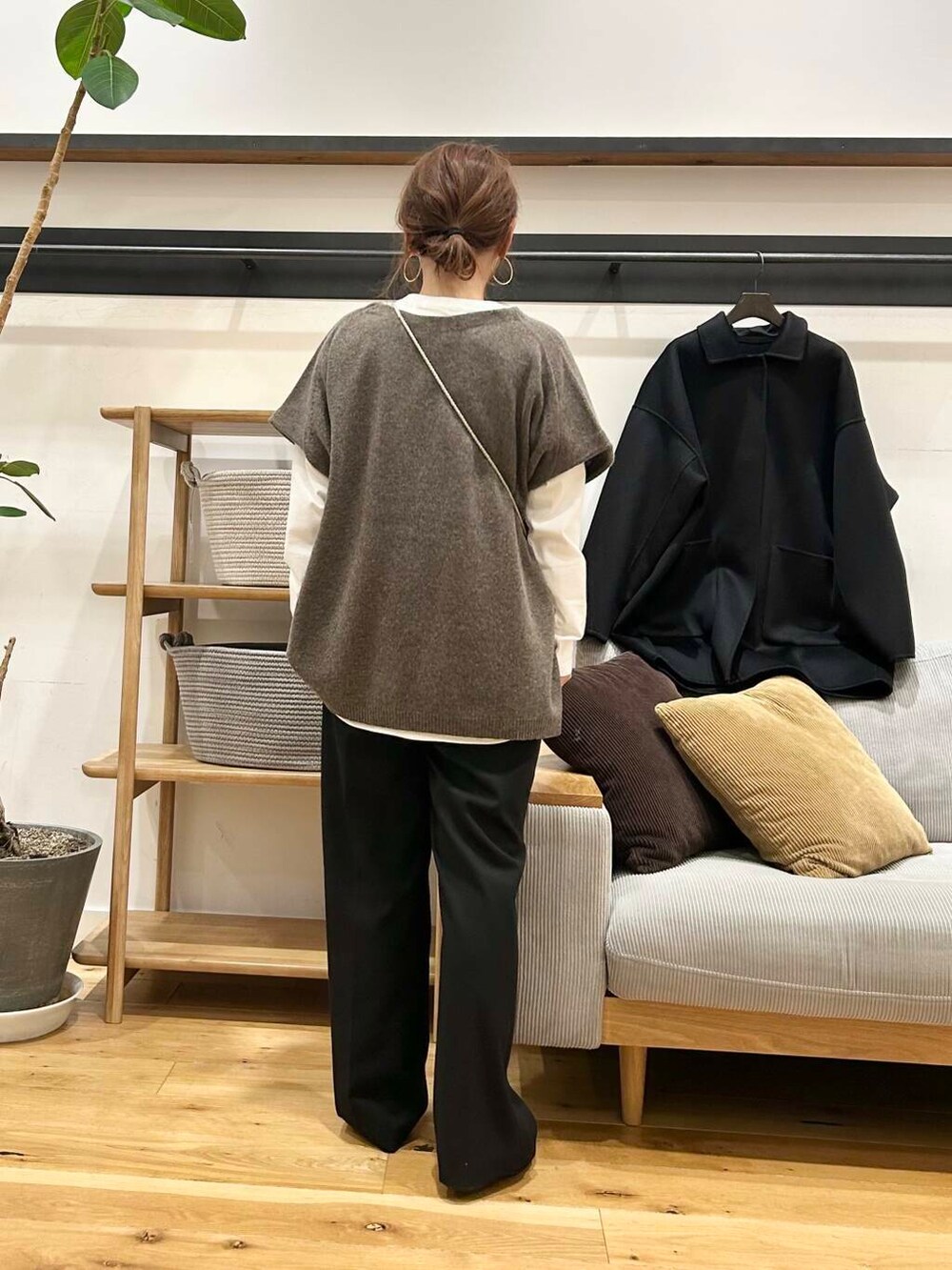 ブラック系のショルダーバッグ、ブラック系のローファー、ブラック系のステンカラーコートを着用したレディースの冬コーディネートの4枚目の写真