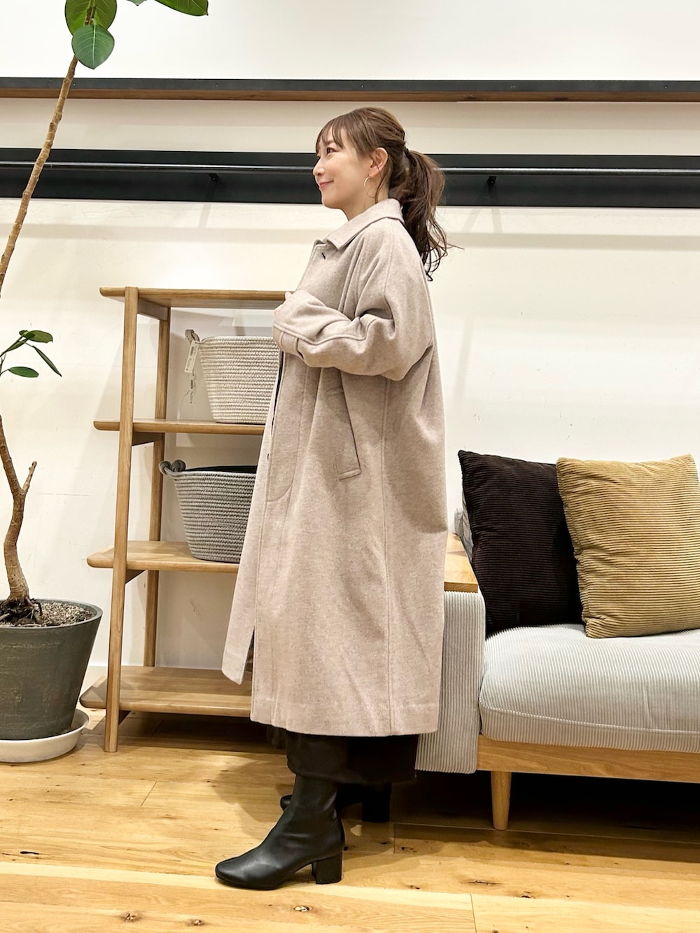 ブラウン系のワンピース、ブラック系のハンドバッグ、ブラック系のブーツを着用したレディースの冬コーディネートの6枚目の写真