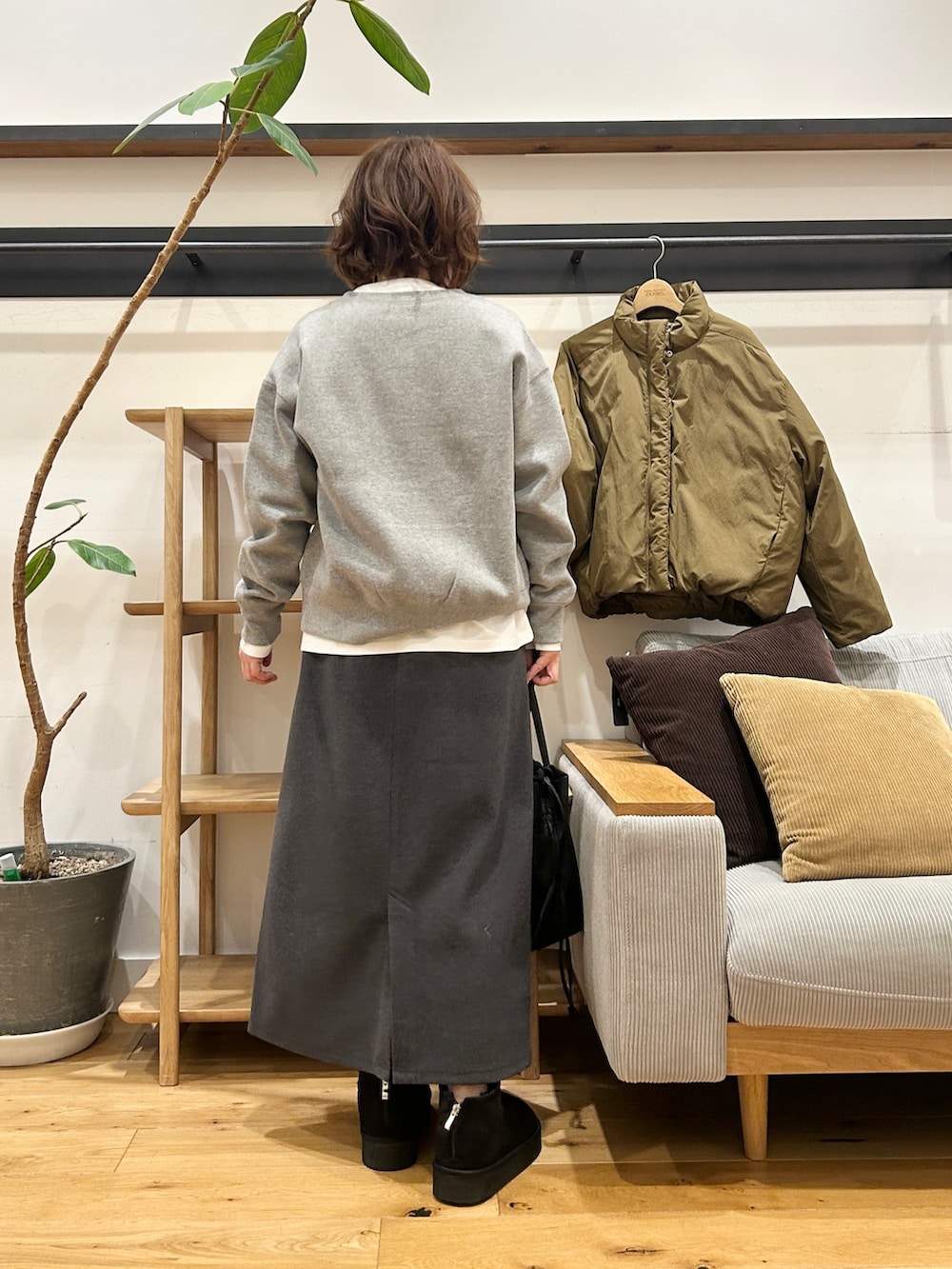 グリーン系のブルゾン、グレー系のカーディガン/ボレロ、グレー系のスカートを着用したレディースの冬コーディネートの3枚目の写真