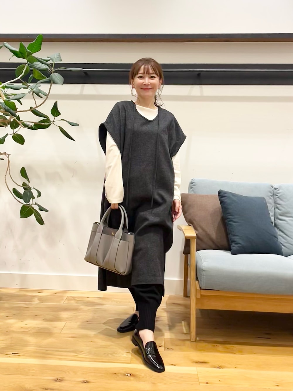グレー系のワンピース、ホワイト系のTシャツ/カットソー、レッド系のトートバッグを着用したレディースの秋コーディネートの2枚目の写真