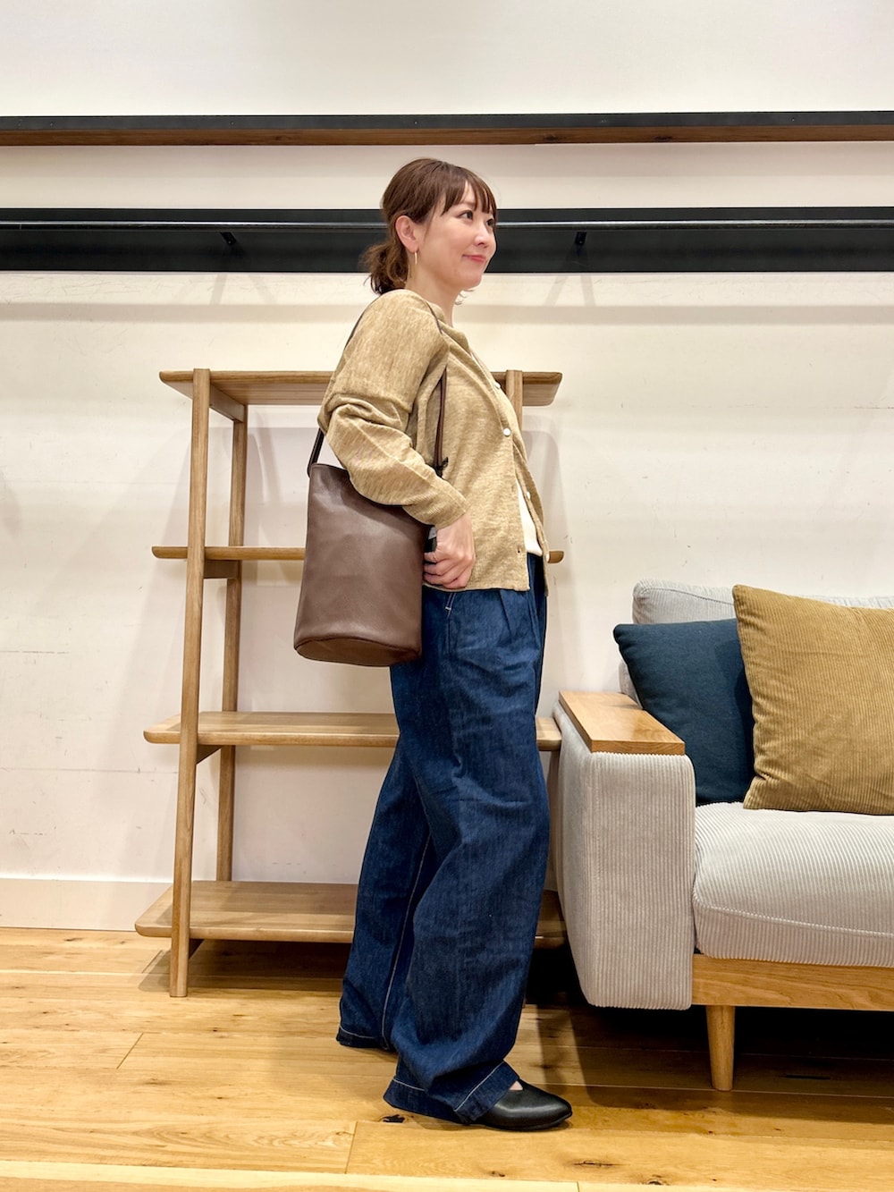 ベージュ系のカーディガン/ボレロ、ホワイト系のタンクトップ、ブルー系のデニムパンツを着用したレディースの春コーディネートの2枚目の写真