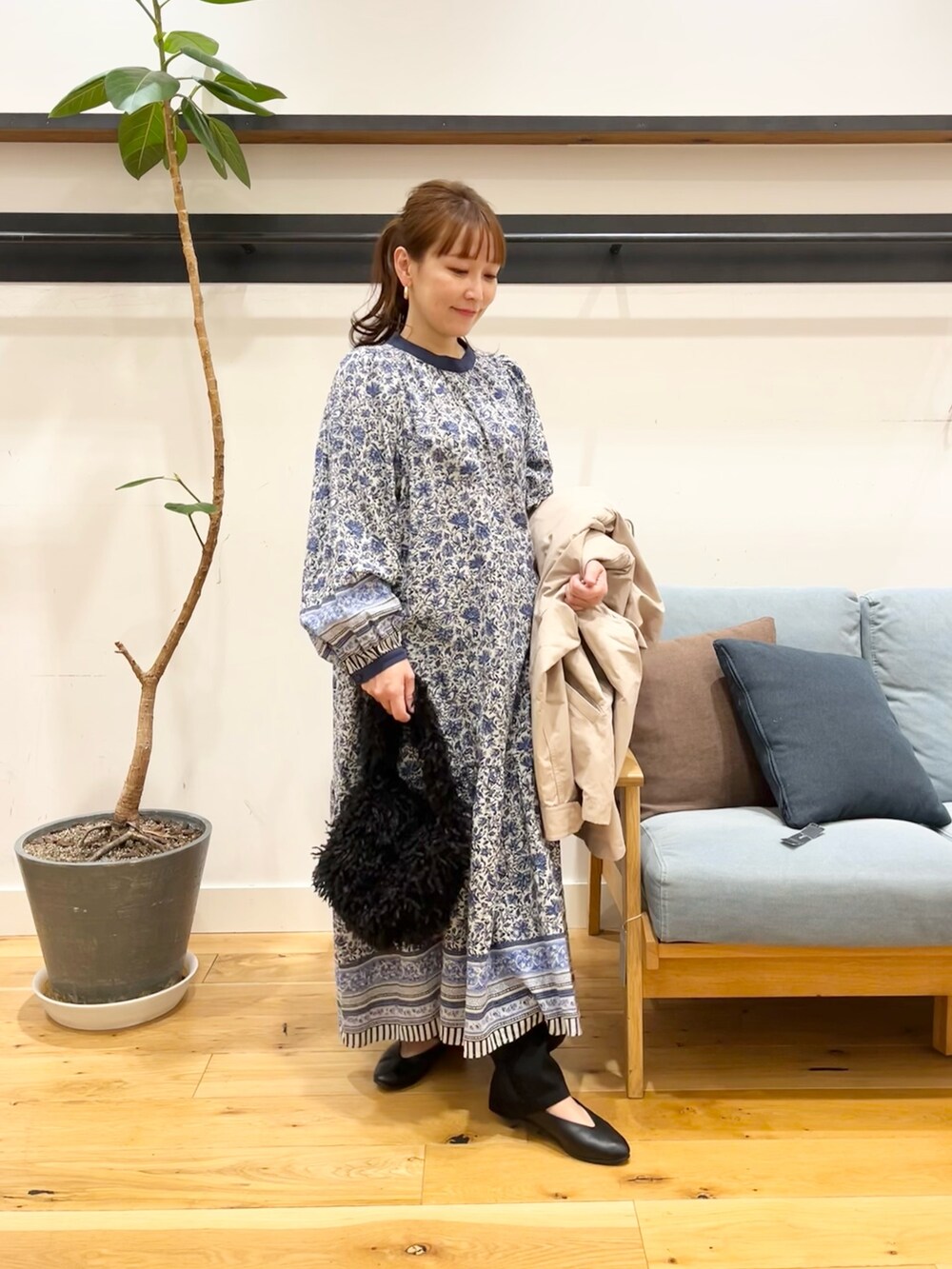 ベージュ系のマウンテンパーカー、ブルー系のワンピース、ブラック系のショルダーバッグを着用したレディースの冬コーディネートの5枚目の写真