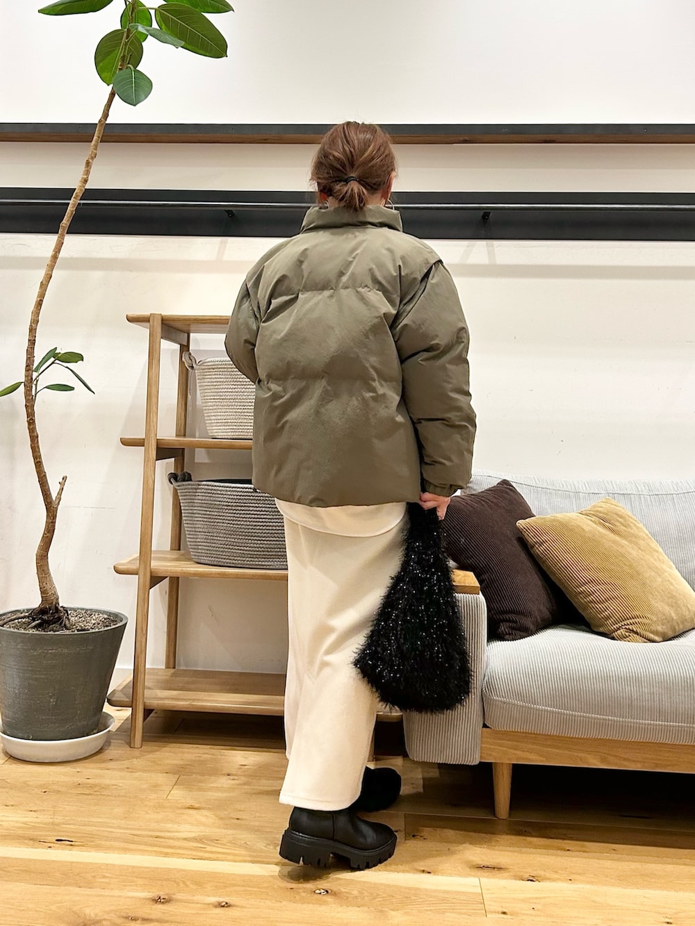 グレー系のニット/セーター、ブラウン系のトートバッグ、ホワイト系のスカートを着用したレディースの冬コーディネートの6枚目の写真