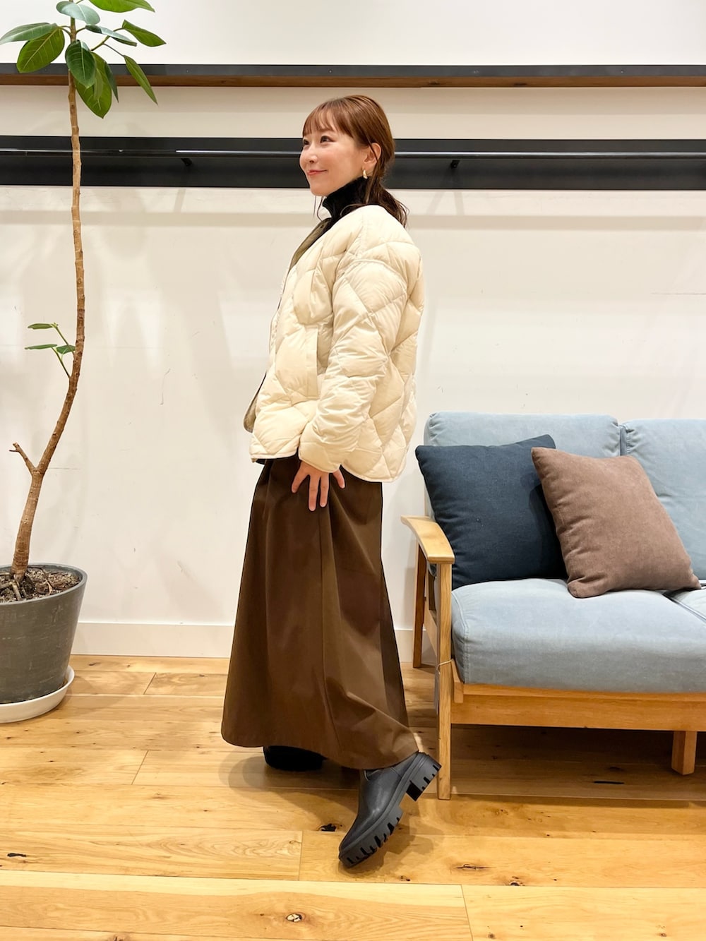 ホワイト系のダウンジャケット/コート、ブラック系のショルダーバッグ、ブラウン系のスカートを着用したレディースの冬コーディネートの3枚目の写真