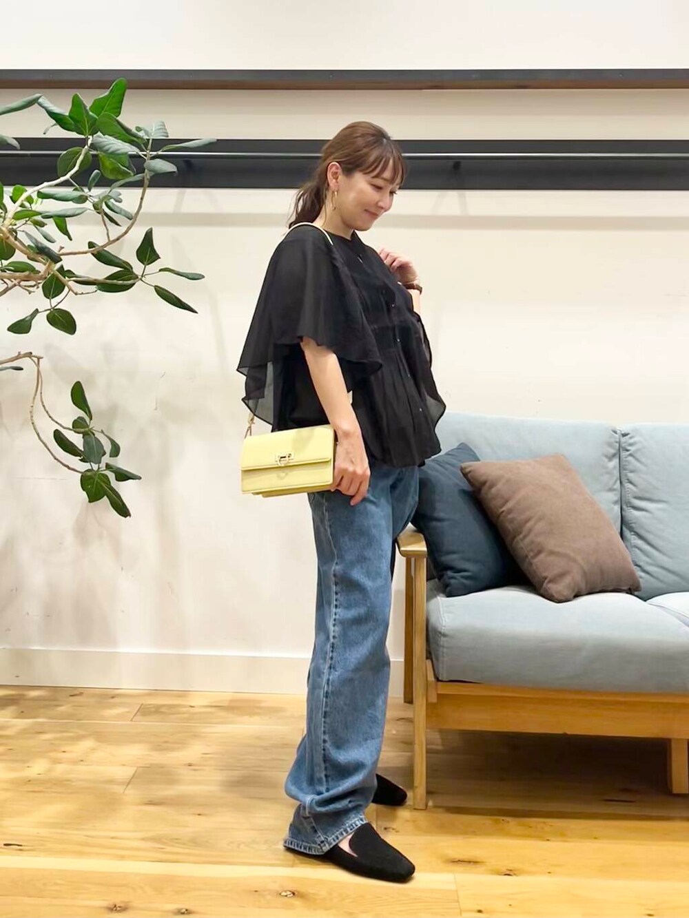 ブルー系のデニムパンツ、ブラック系のシャツ/ブラウス、イエロー系のショルダーバッグを着用したレディースの夏コーディネートの4枚目の写真