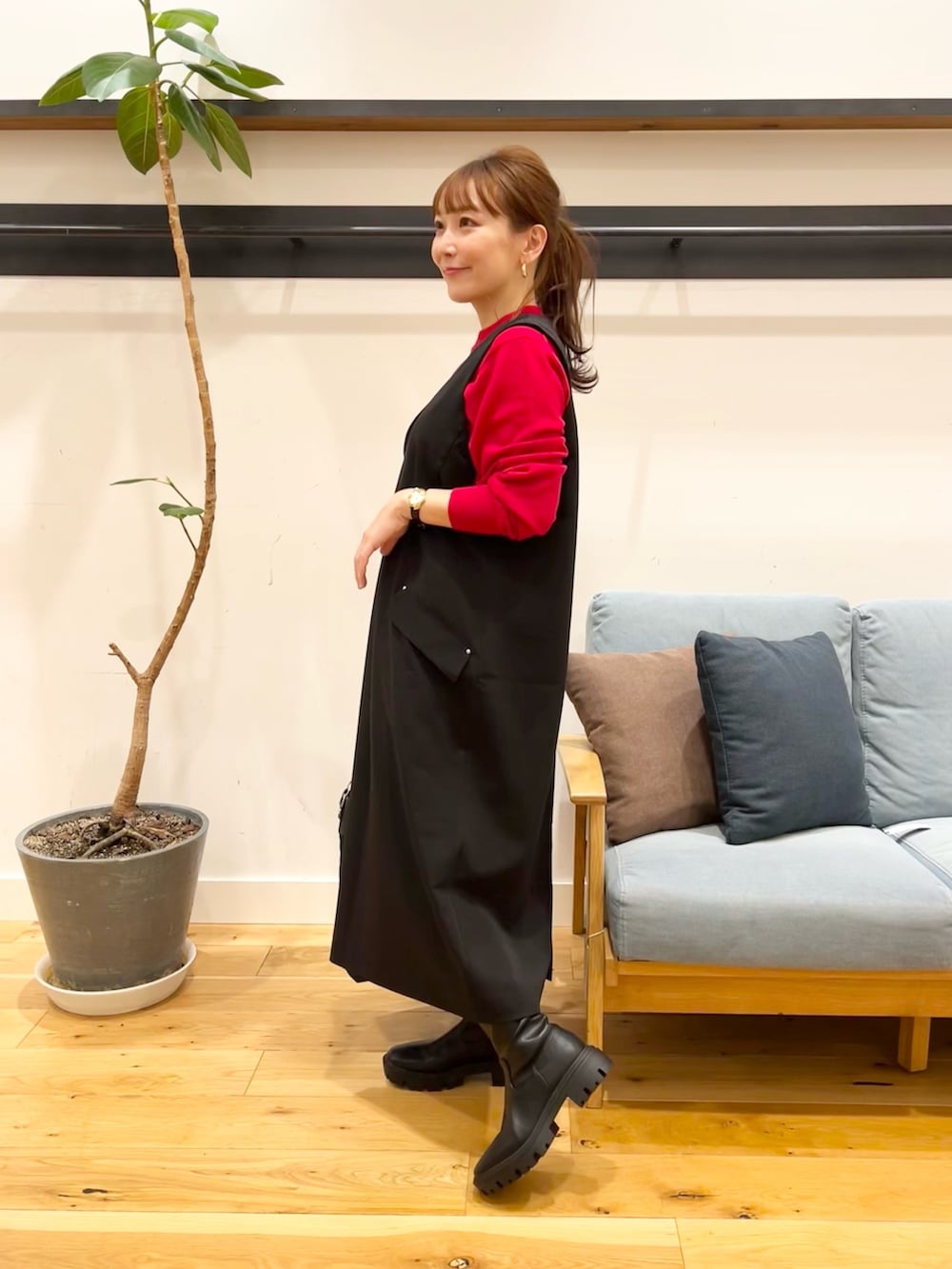 ブラック系のワンピース、レッド系のニット/セーター、ブラック系のトートバッグを着用したレディースの冬コーディネートの2枚目の写真