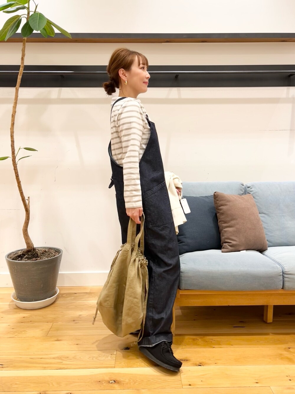 ホワイト系のカーディガン/ボレロ、ベージュ系のTシャツ/カットソー、ブルー系のオールインワン・サロペットを着用したレディースの冬コーディネートの6枚目の写真