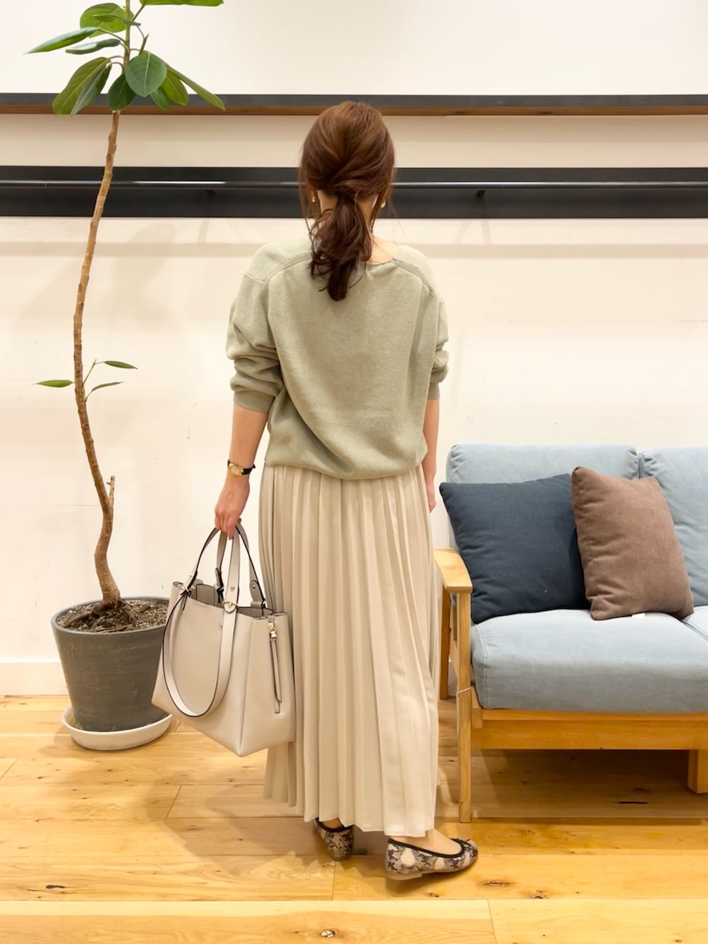 パープル系のニット/セーター、グレー系のスカート、グレー系のトートバッグを着用したレディースの冬コーディネートの3枚目の写真