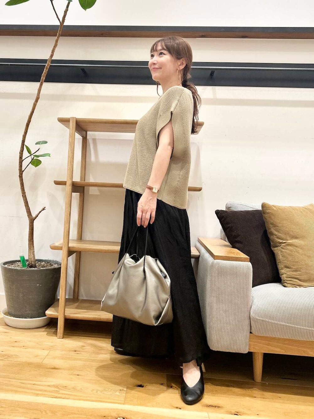 シルバー系のショルダーバッグ、ブラック系のパンプス、ベージュ系のニット/セーターを着用したレディースの夏コーディネートの2枚目の写真