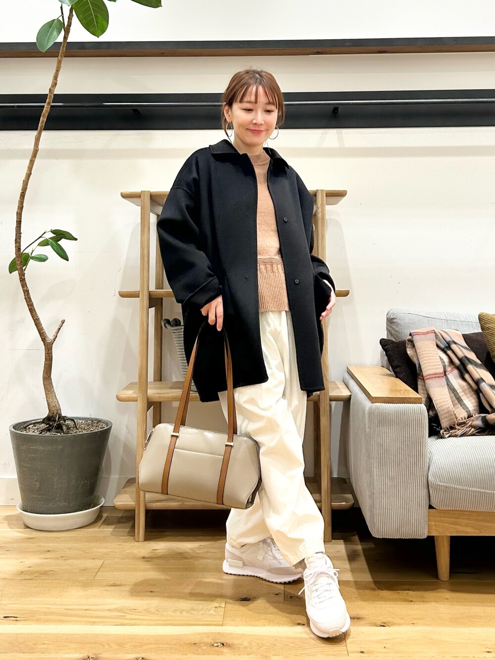 ベージュ系のニット/セーター、ホワイト系のその他パンツ、ブラック系のボストンバッグを着用したレディースの冬コーディネートの5枚目の写真