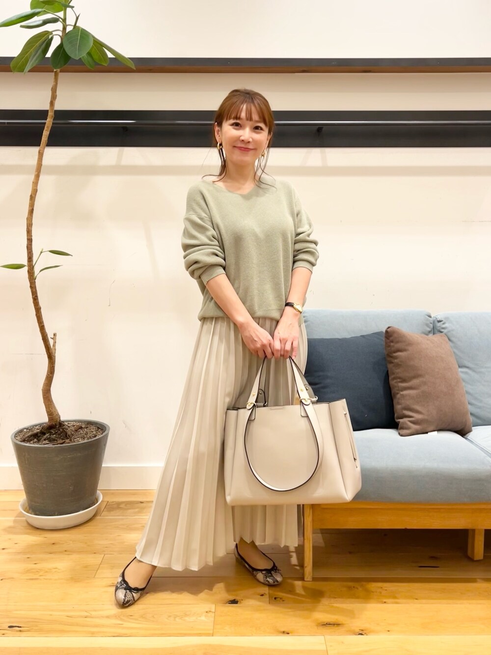 パープル系のニット/セーター、グレー系のスカート、グレー系のトートバッグを着用したレディースの冬コーディネートの4枚目の写真