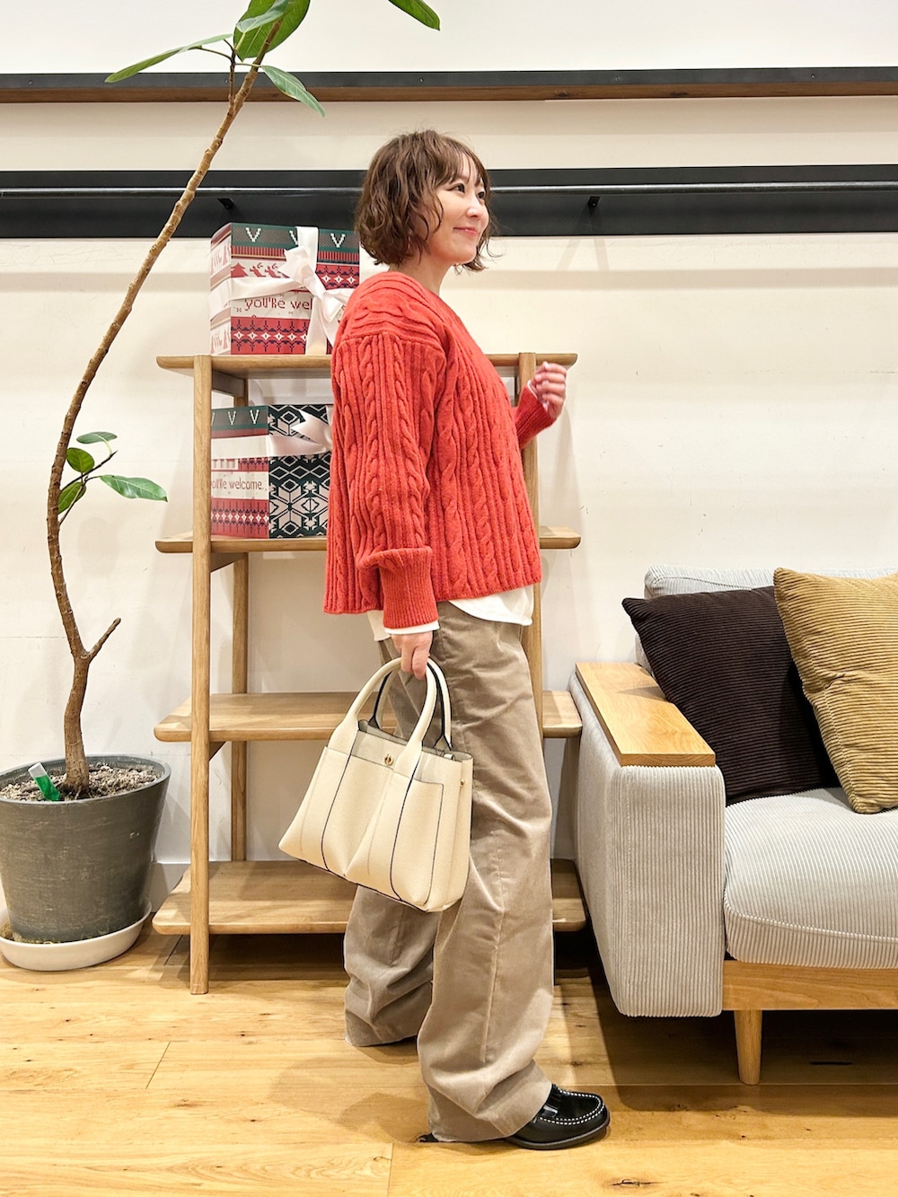 オレンジ系のニット/セーター、ホワイト系のTシャツ/カットソー、ベージュ系のその他パンツを着用したレディースの冬コーディネートの4枚目の写真