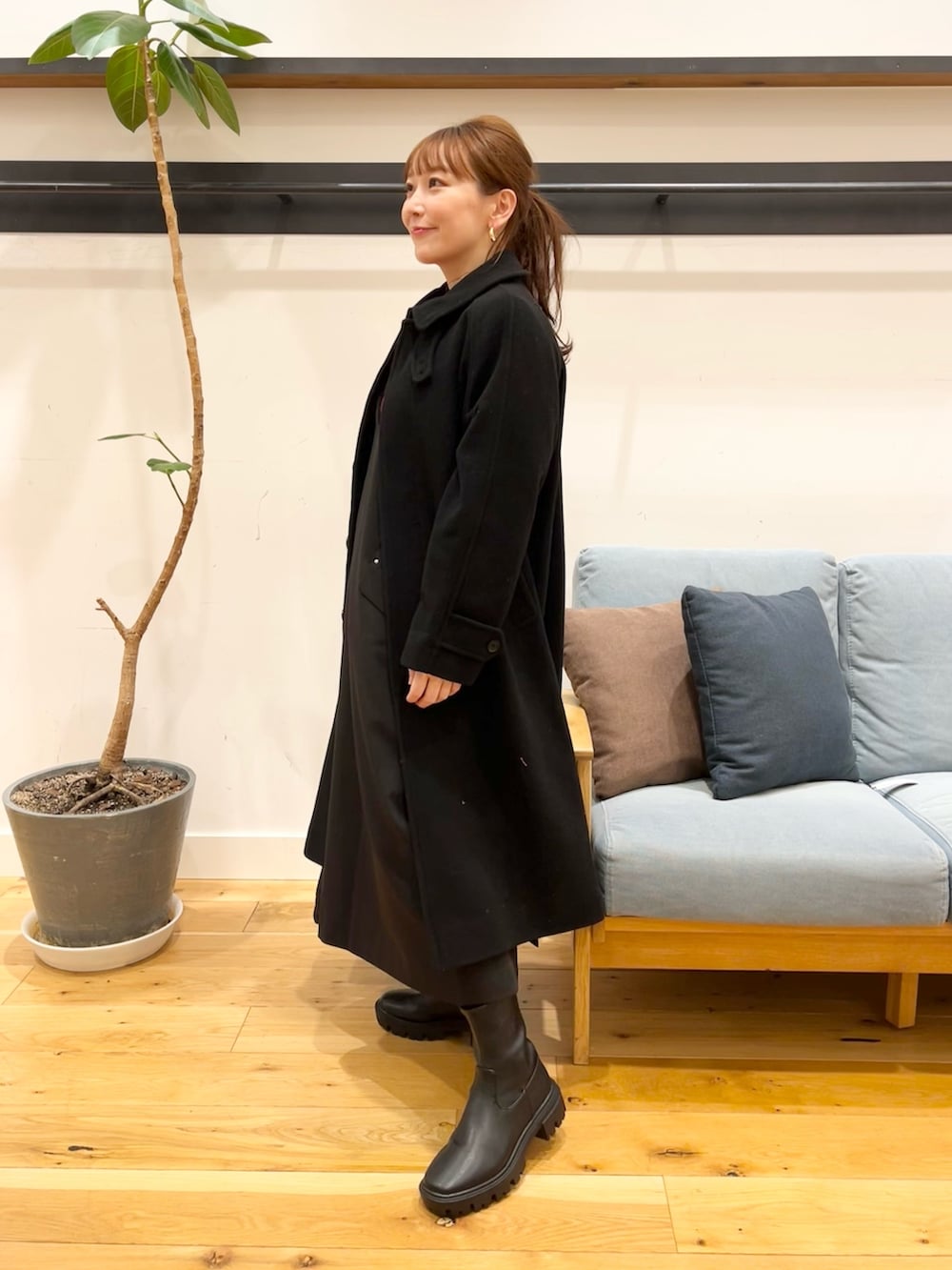 ブラック系のワンピース、レッド系のニット/セーター、ブラック系のトートバッグを着用したレディースの冬コーディネートの4枚目の写真